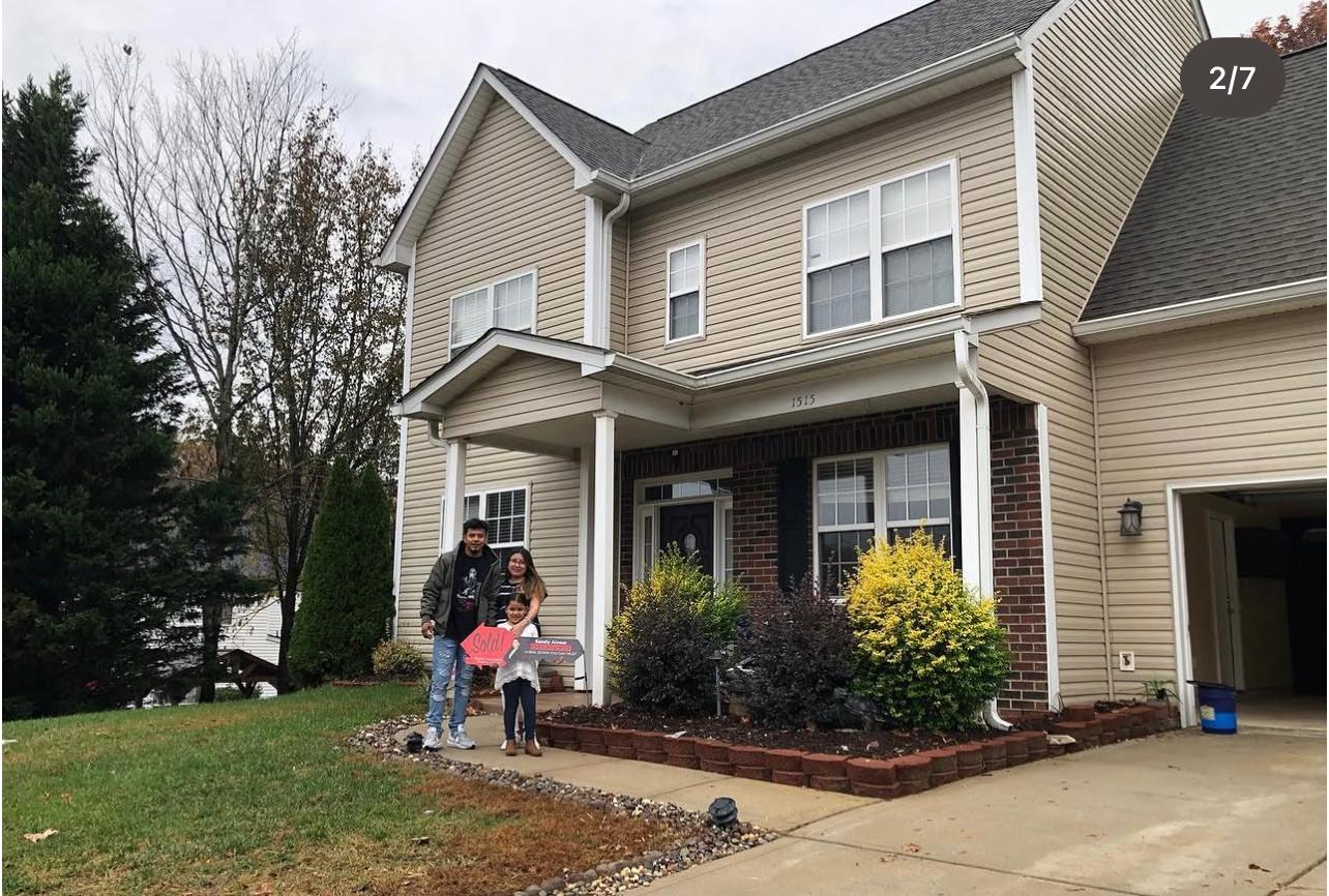 Happy clients with sold sign — Alvear Group